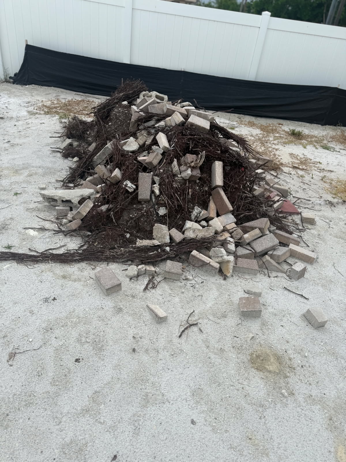 Pile of paver, concrete and root debris before construction debris removal in Fort Myers FL