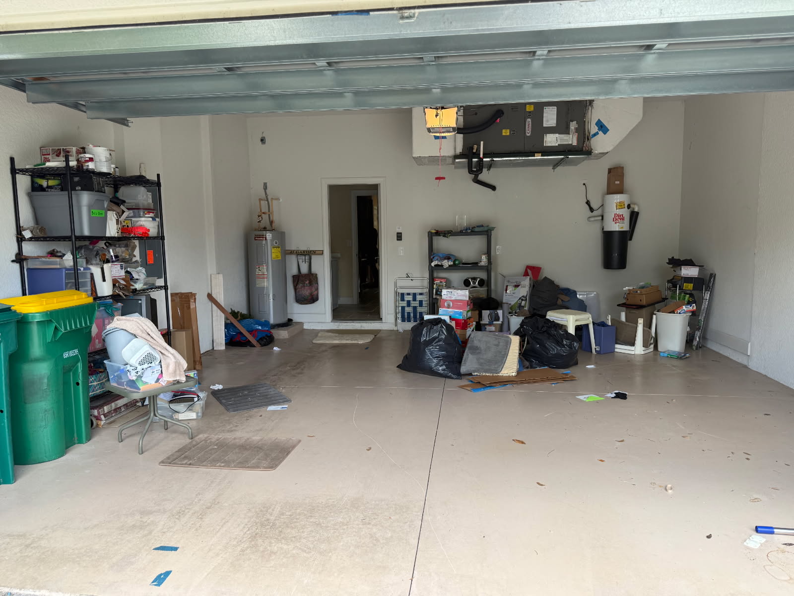 Cluttered two-car garage before cleanout by Triple H The Trash Kings in Fort Myers FL